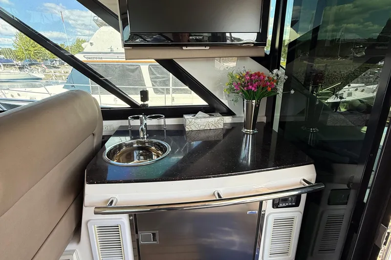  Yacht Photos Pics Interior of 2015 Regal 46 Sport Coupe with sink, TV, and flowers on counter.