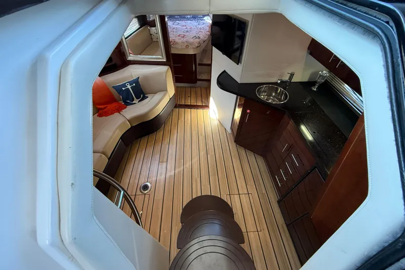  Yacht Photos Pics Interior of 2015 Regal 46 Sport Coupe with wood flooring, kitchenette, and seating area.