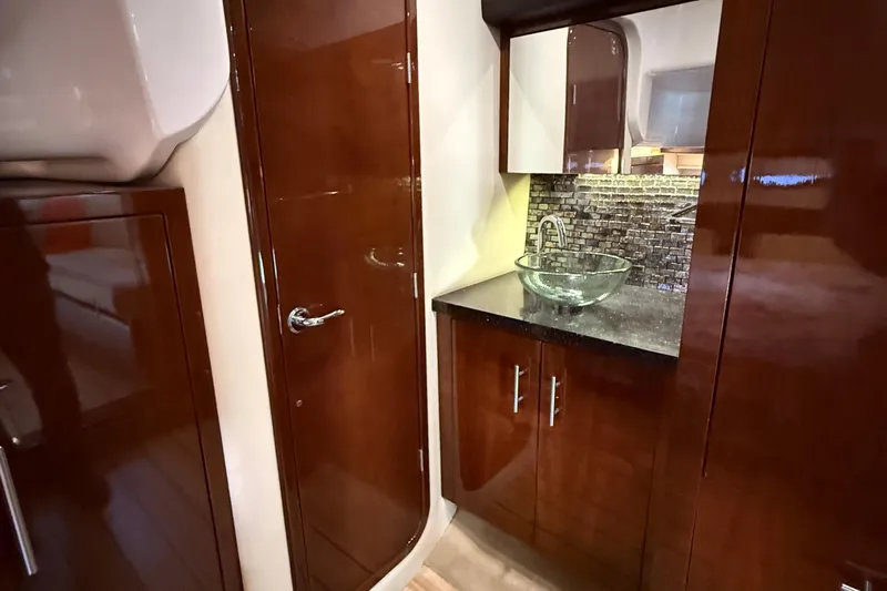  Yacht Photos Pics Luxurious 2015 Regal 46 Sport Coupe bathroom with glass sink and wood cabinetry.