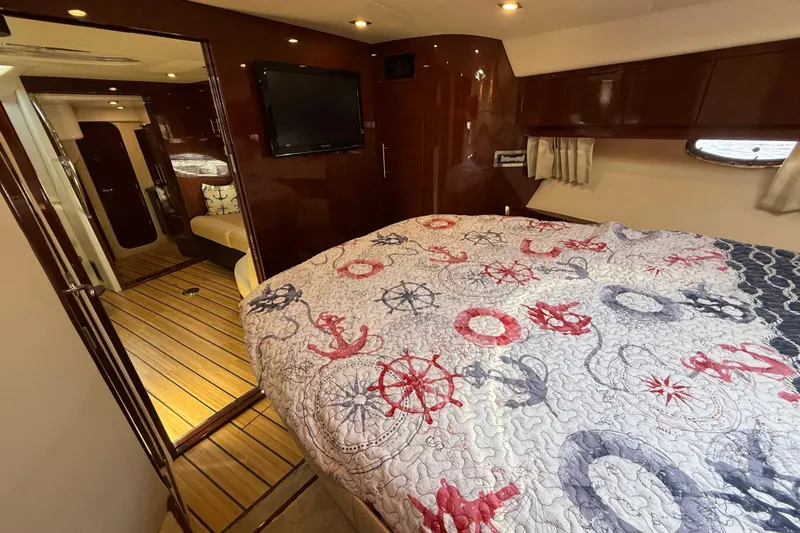  Yacht Photos Pics Interior of 2015 Regal 46 Sport Coupe with nautical-themed bedding and wood flooring.