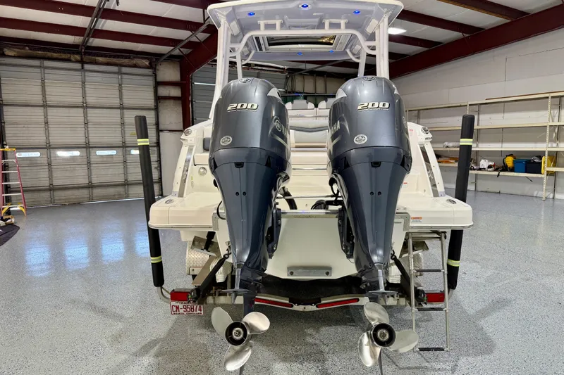  Yacht Photos Pics 2021 Chaparral 280 OSX boat with dual Yamaha 200 engines in a garage setting.