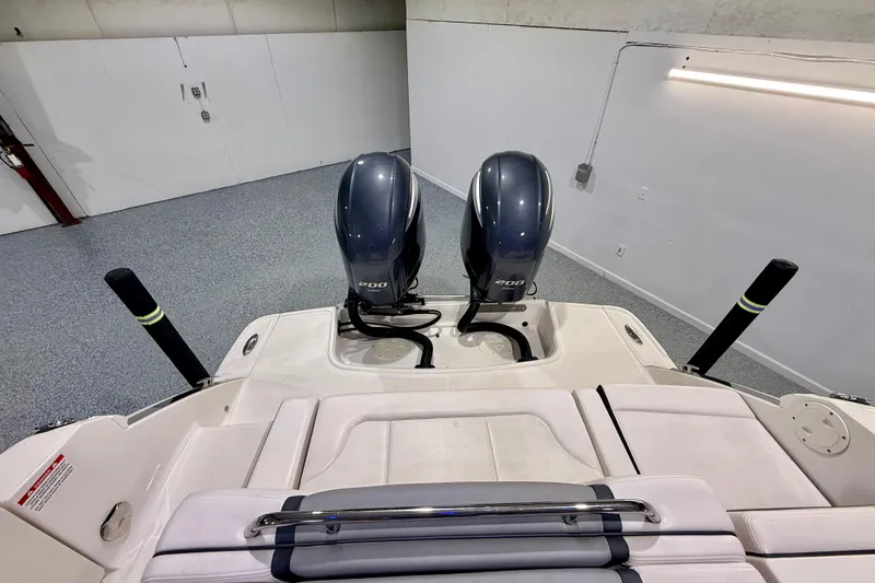  Yacht Photos Pics 2021 Chaparral 280 OSX boat with dual 200 horsepower engines in a garage.