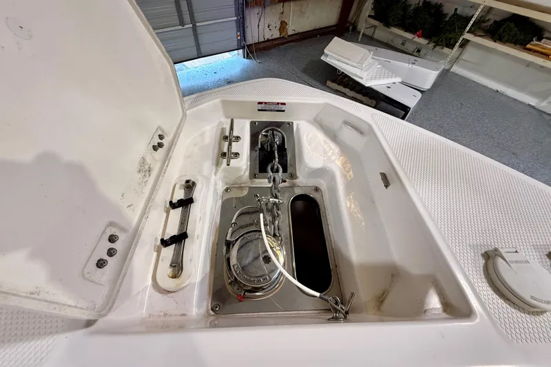  Yacht Photos Pics 2021 Chaparral 280 OSX boat anchor compartment with open hatch in a garage setting.