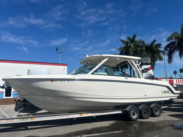 320 Vantage Yacht Photos Pics 2022 Boston Whaler 320 Vantage on trailer, blue sky, palm trees.