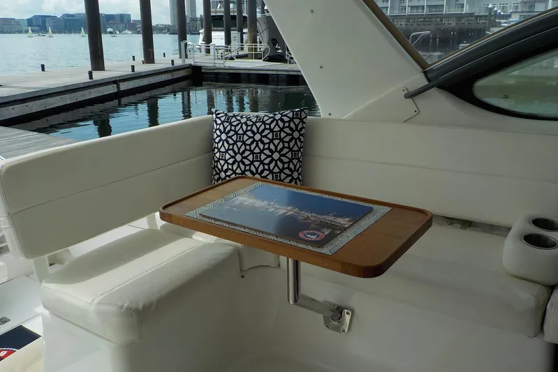 "sapphire" Yacht Photos Pics 2001 Tiara Yachts 3800 Open interior with cushioned seating and wooden table by the dock.