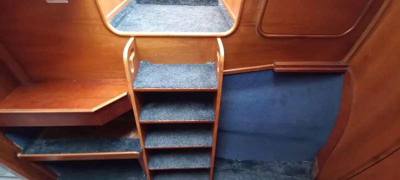 Zarafet Yacht Photos Pics Interior of 1995 Prout 45 yacht with wooden steps and carpeted surfaces.