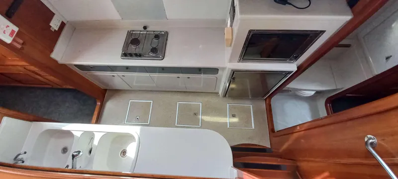 Zarafet Yacht Photos Pics Interior of 1995 Prout 45 yacht kitchen with stove, sink, and storage cabinets.
