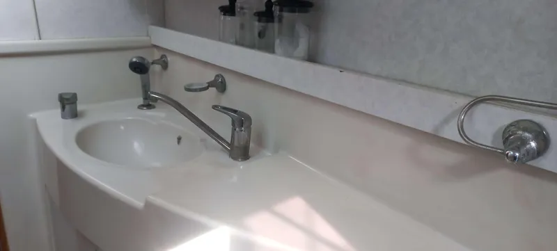 Zarafet Yacht Photos Pics Bathroom sink area in a 1995 Prout 45 yacht, featuring modern fixtures and storage.