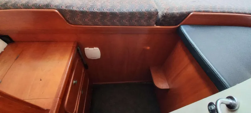 Zarafet Yacht Photos Pics Interior cabin of a 1995 Prout 45 boat with wooden cabinetry and seating.