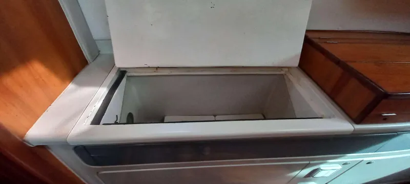 Zarafet Yacht Photos Pics Open storage compartment on a 1995 Prout 45 boat, featuring wooden and white surfaces.