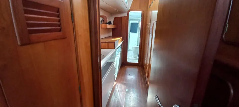 Zarafet Yacht Photos Pics Interior of 1995 Prout 45 yacht, featuring wooden cabinetry and narrow passageway.