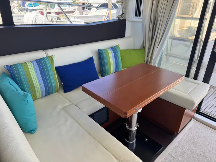 Portkey Yacht Photos Pics Interior of 2016 Jeanneau Velasco 37F yacht with colorful cushions and wooden table.