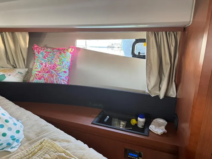 Portkey Yacht Photos Pics Cozy cabin interior of 2016 Jeanneau Velasco 37F with colorful pillows and window view.
