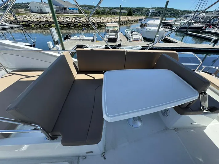 Portkey Yacht Photos Pics Flybridge seating area on 2016 Jeanneau Velasco 37F yacht, docked at marina.
