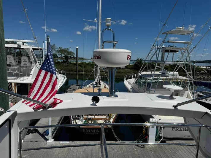 Portkey Yacht Photos Pics Jeanneau Velasco 37F yacht docked, American flag, clear sky, marina setting, 2016 model.