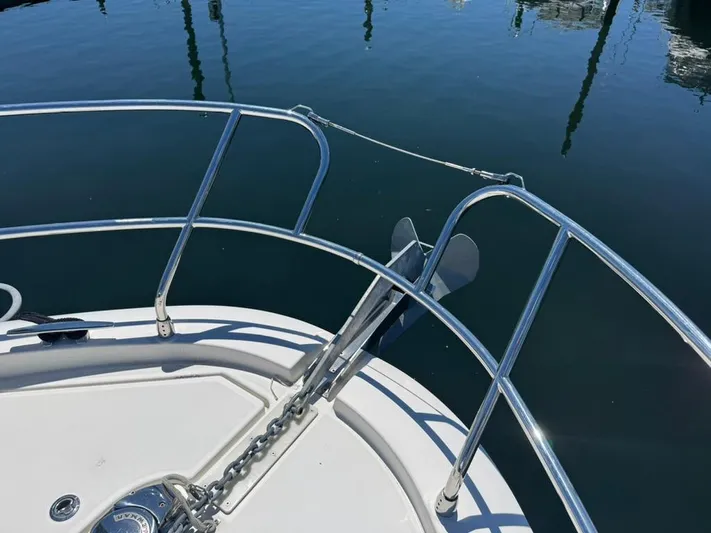 Portkey Yacht Photos Pics Bow of 2016 Jeanneau Velasco 37F with anchor and railing, reflecting on calm water.
