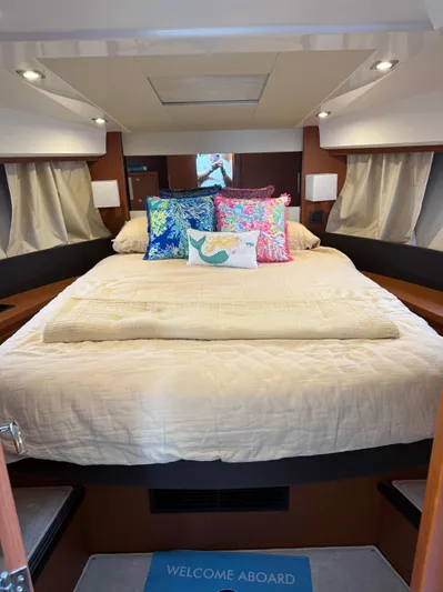 Portkey Yacht Photos Pics Cozy bedroom in 2016 Jeanneau Velasco 37F yacht with colorful pillows and welcome mat.