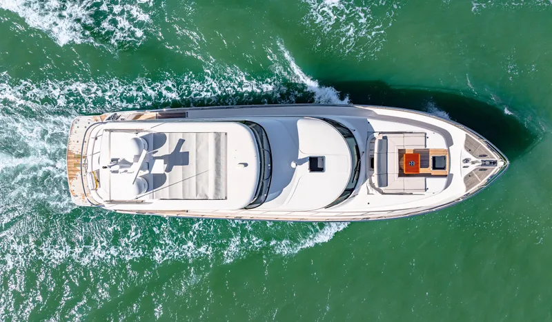 Dog House Yacht Photos Pics Aerial view of 2025 Belize 66 Daybridge yacht cruising on green water.