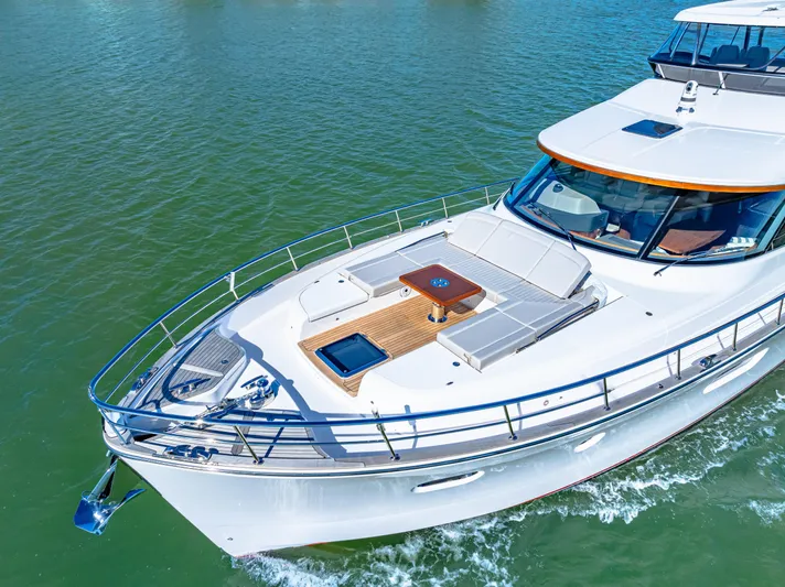 Dog House Yacht Photos Pics 2025 Belize 66 Daybridge yacht cruising on clear waters, showcasing sleek design and luxury features.