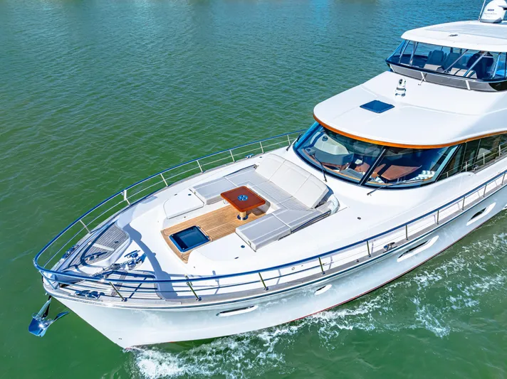 Dog House Yacht Photos Pics 2025 Belize 66 Daybridge yacht cruising on calm waters, showcasing sleek design and luxury features.