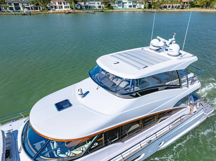 Dog House Yacht Photos Pics 2025 Belize 66 Daybridge luxury yacht cruising on a serene waterway.