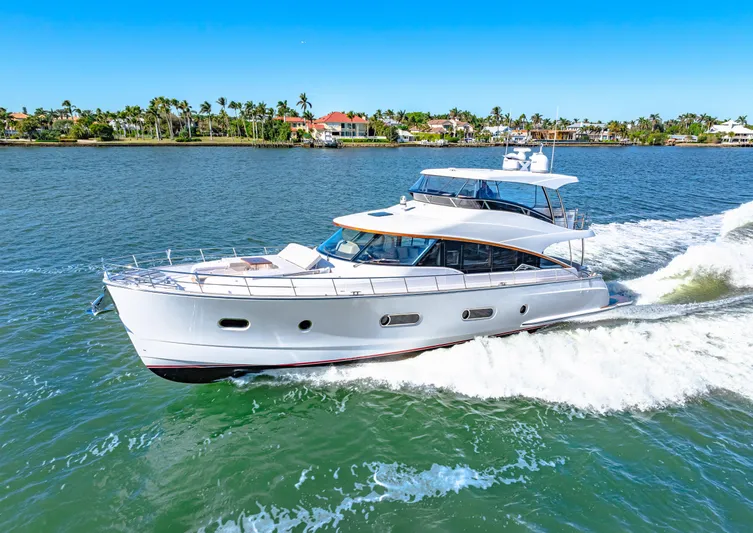Dog House Yacht Photos Pics 2025 Belize 66 Daybridge yacht cruising on a sunny day, surrounded by calm waters and palm trees.