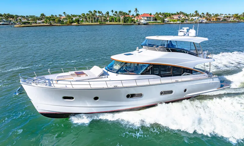 Dog House Yacht Photos Pics 2025 Belize 66 Daybridge yacht cruising on a sunny day, surrounded by calm waters and lush shoreline.