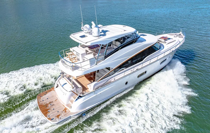 Dog House Yacht Photos Pics 2025 Belize 66 Daybridge yacht cruising on open water, showcasing sleek design and luxury features.