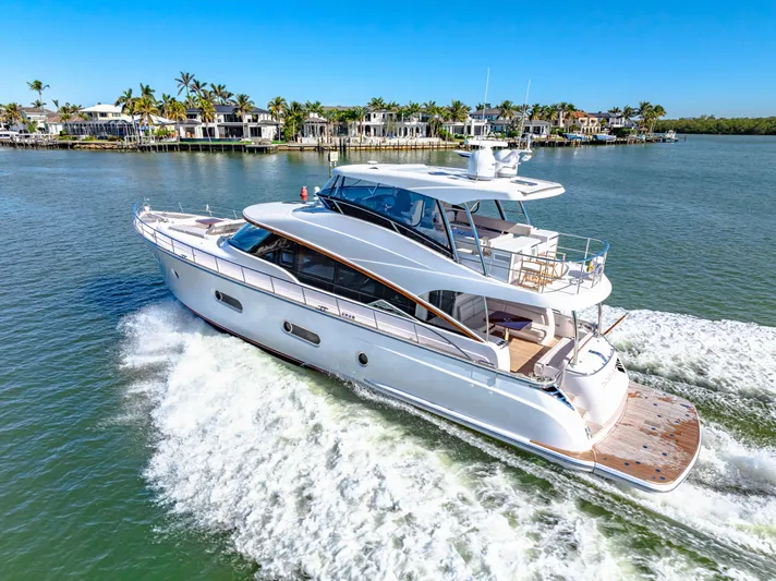 Dog House Yacht Photos Pics 2025 Belize 66 Daybridge yacht cruising on a sunny day near waterfront homes.