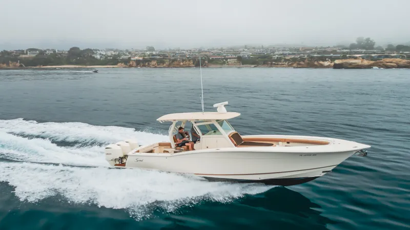 Last Look Yacht Photos Pics 2016 Scout 350 LXF boat cruising on open water near coastline.