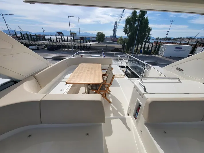 Yacht Photos Pics Flybridge of 2017 Absolute NAVETTA 58 yacht with seating and table, docked at marina.