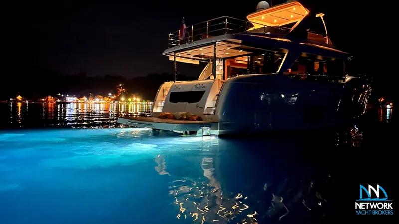  Yacht Photos Pics Luxurious 2017 Absolute NAVETTA 58 yacht illuminated at night on calm waters.