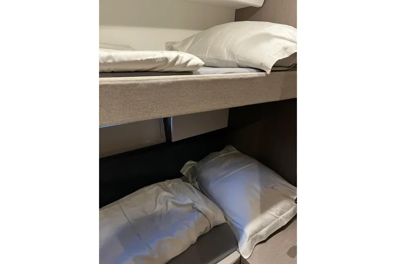  Yacht Photos Pics Bunk beds in 2024 Beneteau Gran Turismo 45 yacht cabin, featuring cozy bedding.