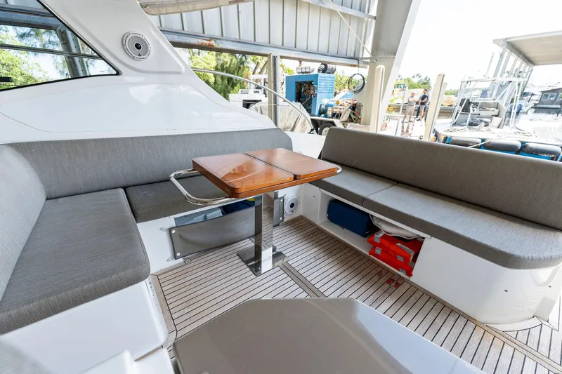 Ice II Yacht Photos Pics 2017 Azimut Atlantis 43 yacht interior seating area with wooden table.