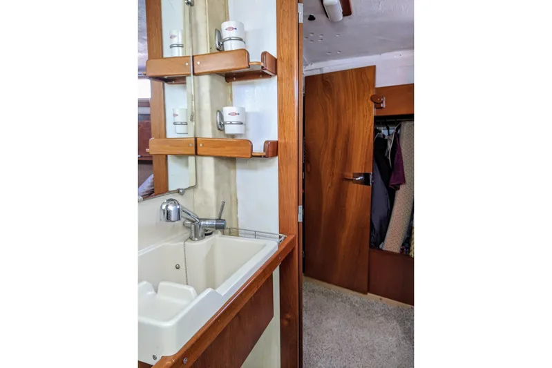 Omorfi Thea Yacht Photos Pics Interior of 1993 Amel Santorin yacht showing sink, wooden shelves, and closet.