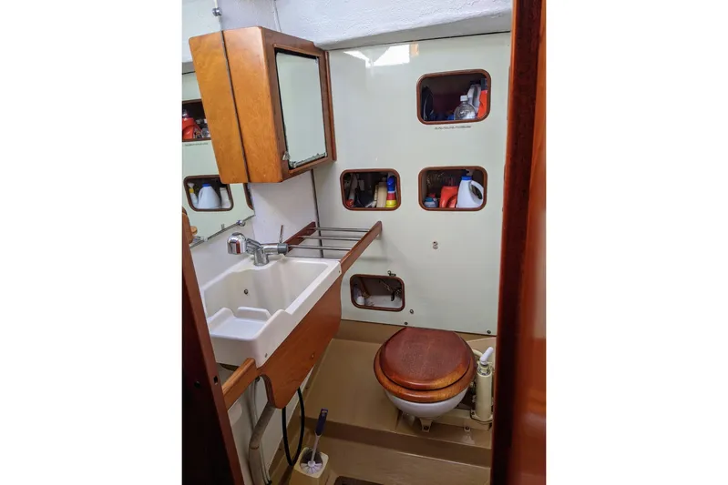 Omorfi Thea Yacht Photos Pics Bathroom interior of 1993 Amel Santorin yacht with sink and wooden toilet seat.