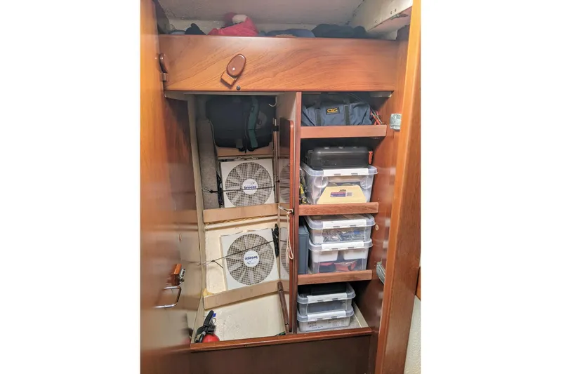 Omorfi Thea Yacht Photos Pics Storage area in a 1993 Amel Santorin yacht with organized shelves and cooling fans.