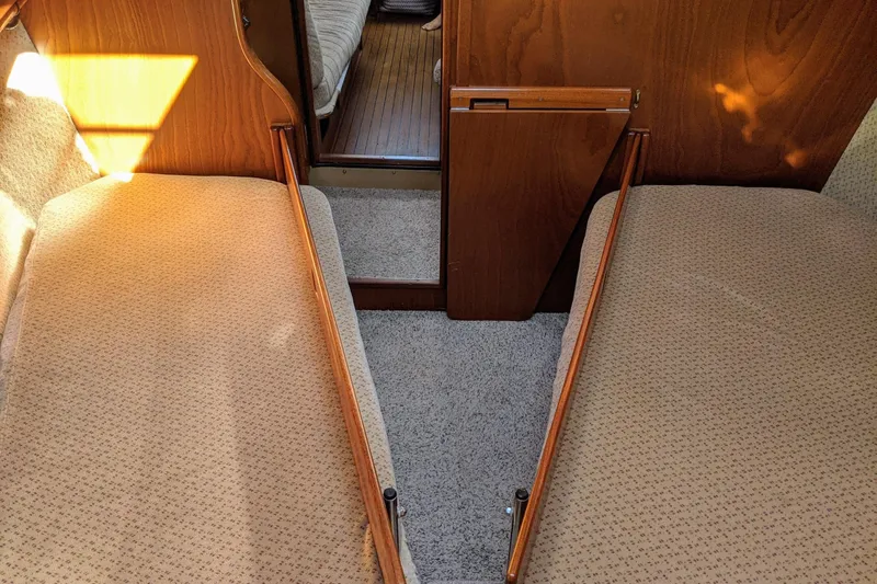 Omorfi Thea Yacht Photos Pics Interior of 1993 Amel Santorin yacht with twin beds and wooden paneling.