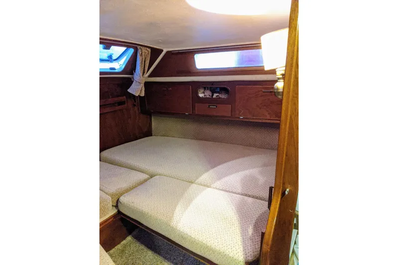 Omorfi Thea Yacht Photos Pics Cozy cabin interior of 1993 Amel Santorin sailboat with cushioned seating and wooden accents.