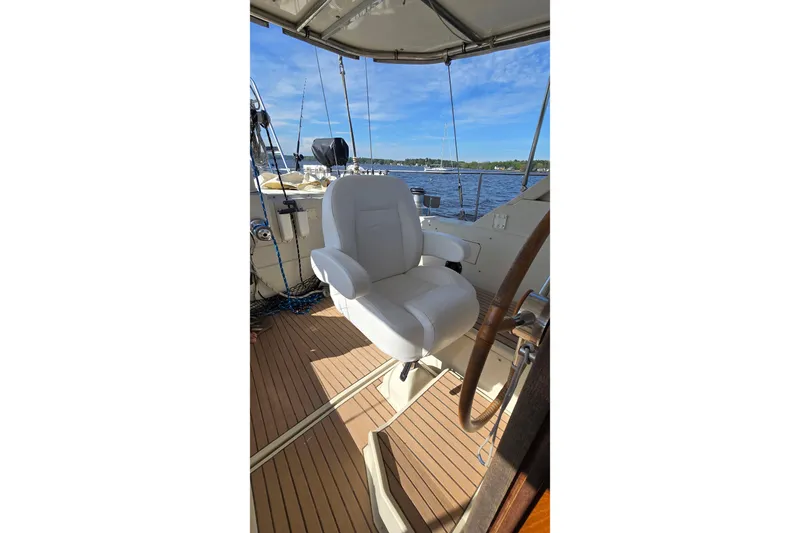Omorfi Thea Yacht Photos Pics Captain's chair on 1993 Amel Santorin yacht, overlooking serene waters and clear blue sky.