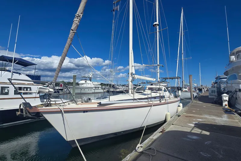 Omorfi Thea Yacht Photos Pics Sailboat Amel Santorin 1993 docked at marina under clear blue sky.