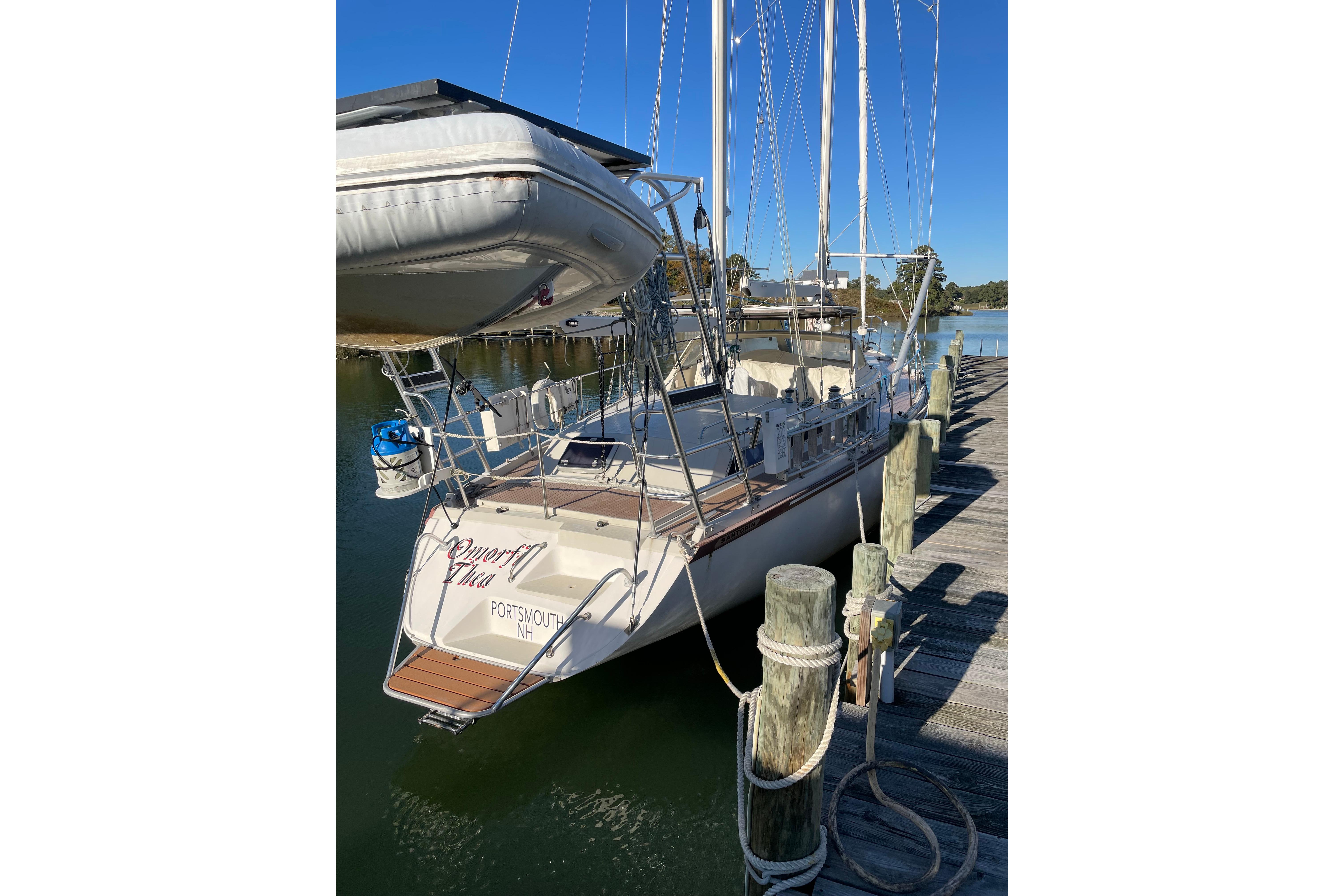 1993 Amel Santorin sailboat docked at a marina, clear blue sky background.