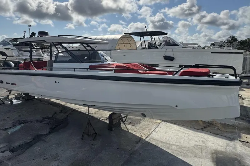 Kraken Yacht Photos Pics 2023 BRABUS Shadow 900 ST boat with sleek design and red seating, docked under cloudy sky.