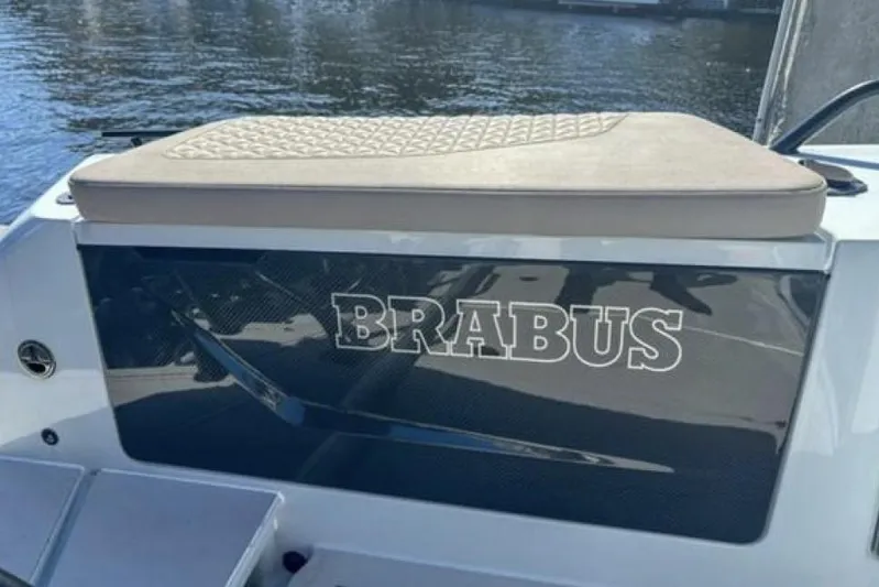 Kraken Yacht Photos Pics 2023 BRABUS Shadow 900 ST boat with cushioned seating, docked by the water.