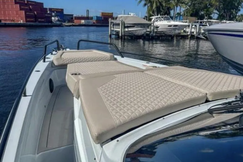 Kraken Yacht Photos Pics 2023 BRABUS Shadow 900 ST luxury boat with beige cushioned deck, docked in marina.