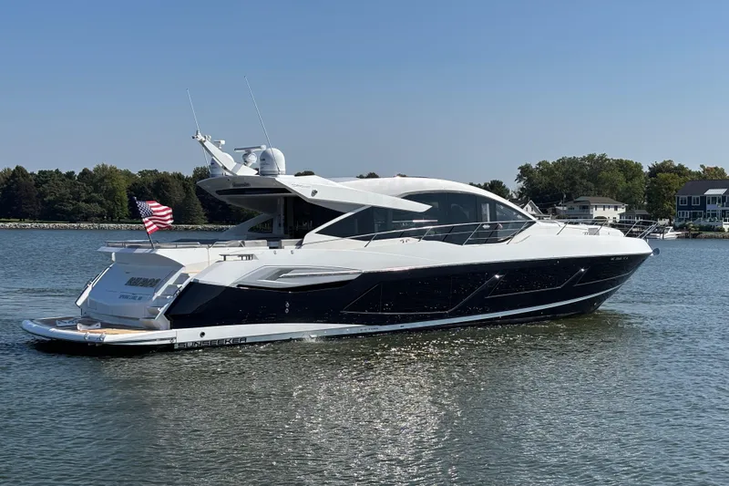  Yacht Photos Pics 2018 Sunseeker Predator 74 yacht cruising on a calm lake with American flag.