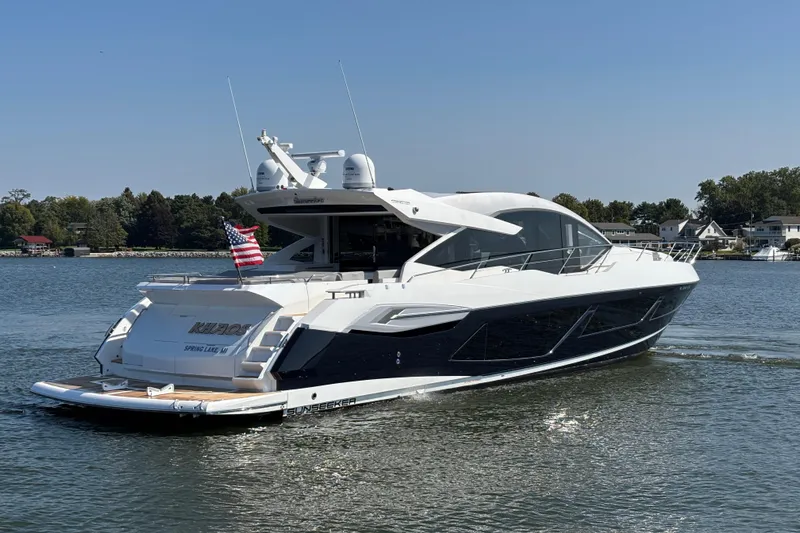  Yacht Photos Pics 2018 Sunseeker Predator 74 yacht cruising on a serene lake with clear skies.