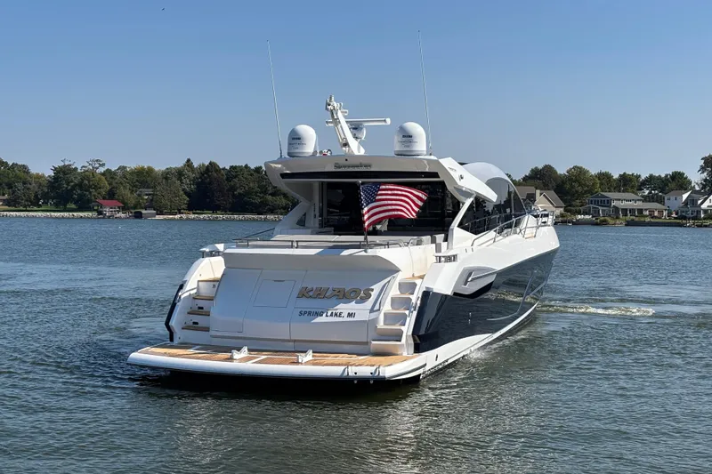  Yacht Photos Pics 2018 Sunseeker Predator 74 yacht on water, displaying American flag, rear view.