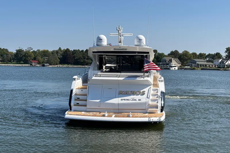  Yacht Photos Pics Sunseeker Predator 74 yacht on water, rear view, with American flag, 2018 model.