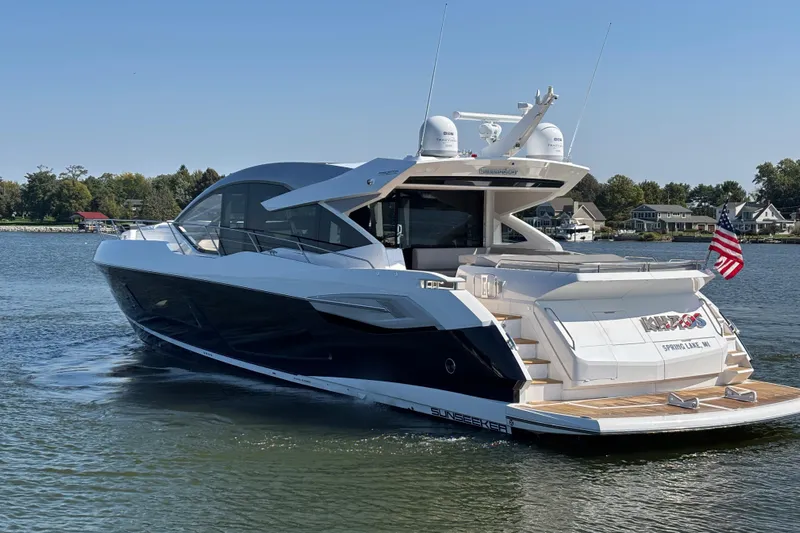  Yacht Photos Pics 2018 Sunseeker Predator 74 yacht cruising on a serene lake with American flag.